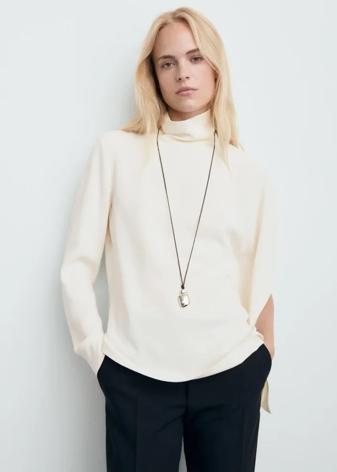 Bluse mit hohem Kragen und asymmetrischen Ärmeln Bluse mit hohem Kragen und asymmetrischen Ärmeln