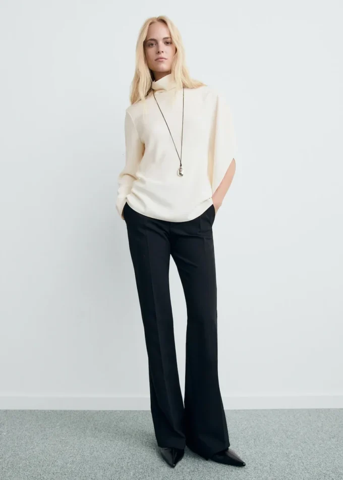 Bluse mit hohem Kragen und asymmetrischen Ärmeln Bluse mit hohem Kragen und asymmetrischen Ärmeln