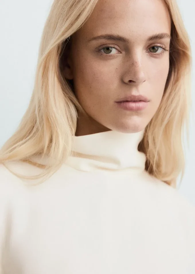 Bluse mit hohem Kragen und asymmetrischen Ärmeln Bluse mit hohem Kragen und asymmetrischen Ärmeln